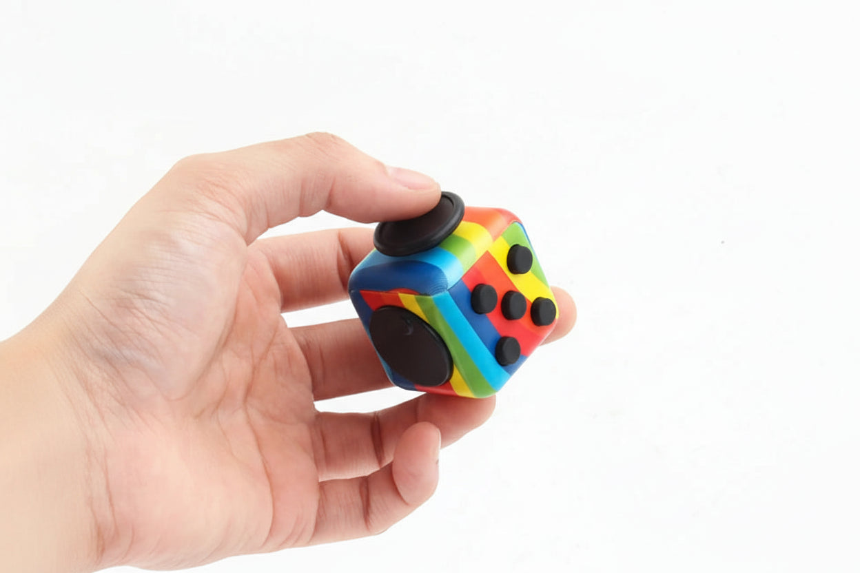 Imagen de una mano sujetando un juguete sensorial tipo fidget con forma de dado | Neuromart