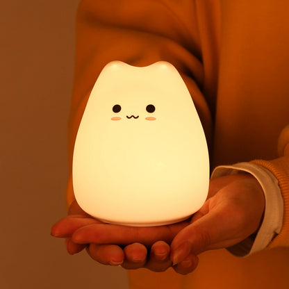 Imagen de una mini lampara gatito encendida sujetada por manos | Neuromart