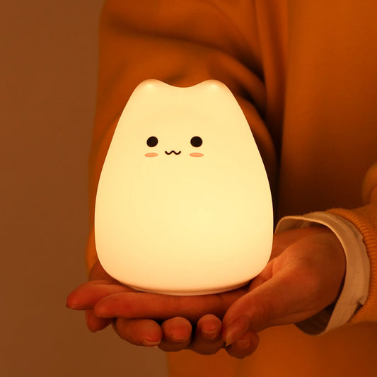 Imagen de una mini lampara gatito encendida sujetada por manos | Neuromart