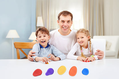 Imagen de padre e hijos con juguete sensorial con forma de piedra